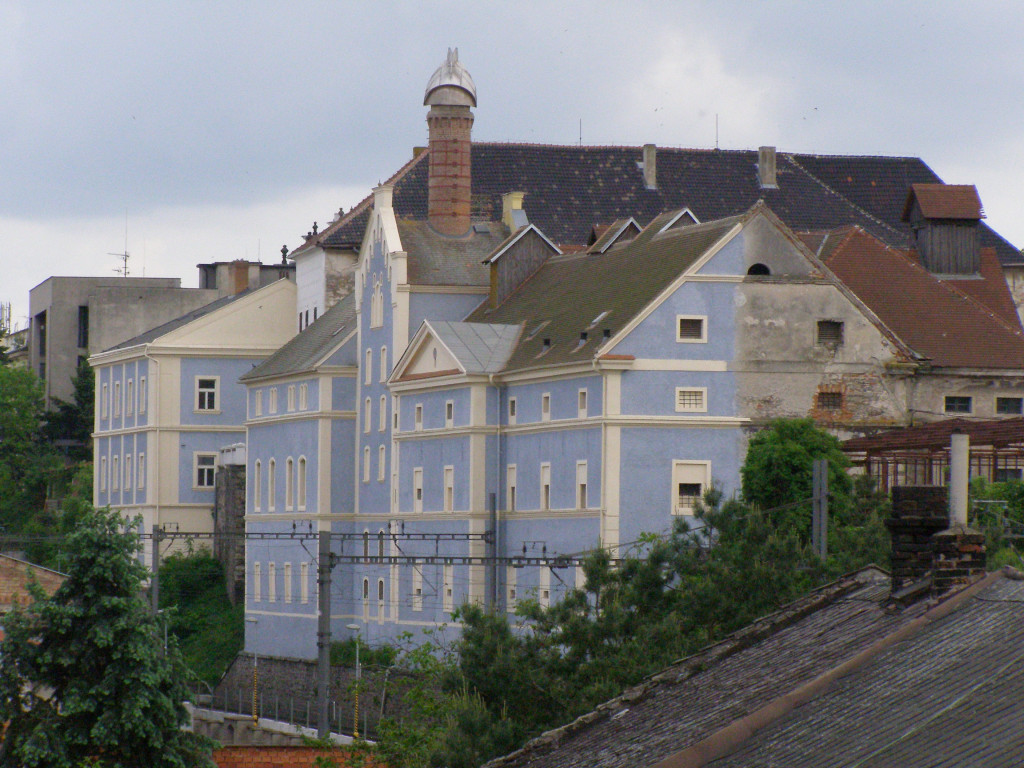 Castle in Kolín with new facade and crumbling building behind.