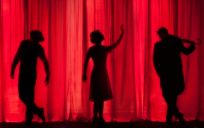 silhouettes of three people on a stage