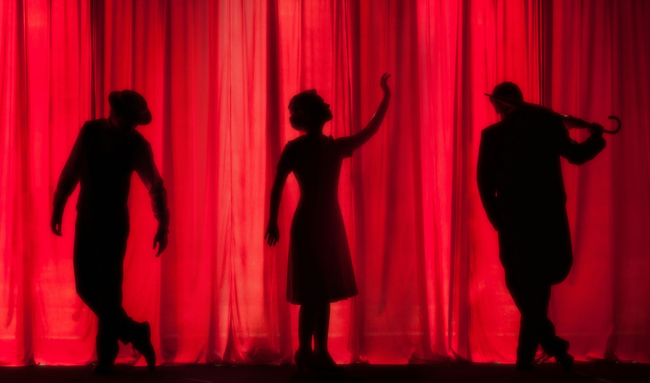 silhouettes of three people on a stage