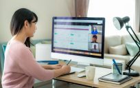 Woman in meeting, sitting at computer.