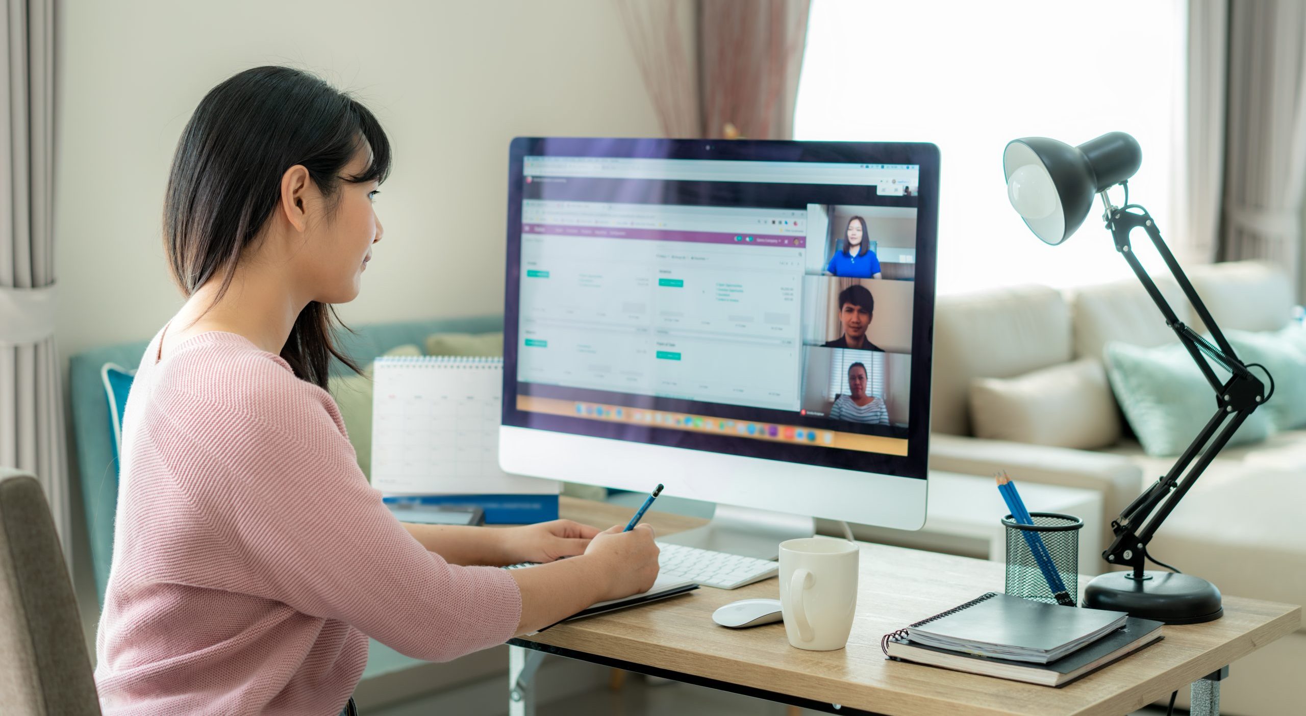 Woman in meeting, sitting at computer.